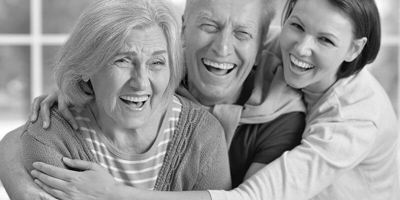 Happy adult daughter and retired parents embracing