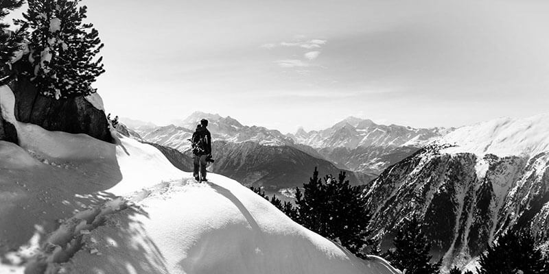 Figure trekking through the snow with a view of the mountains