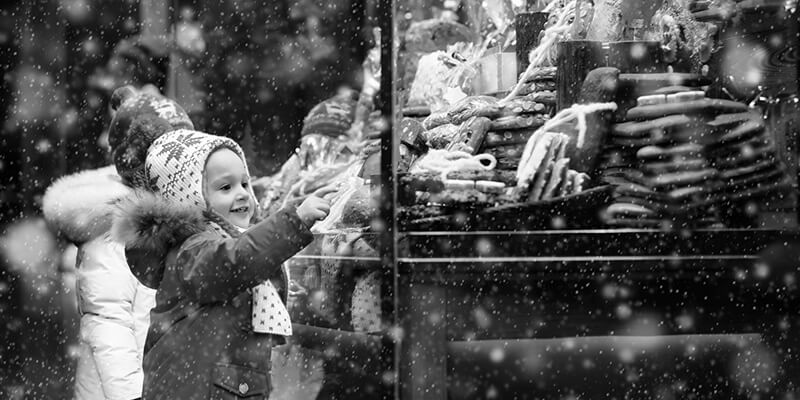 Small child looking at a festive window display