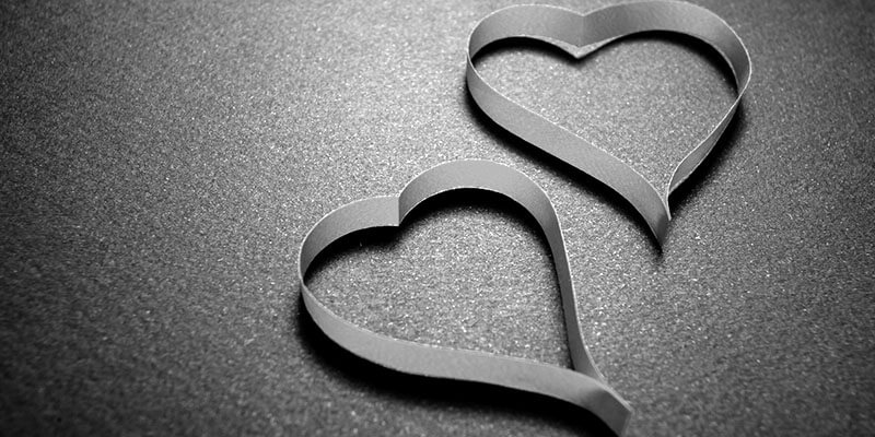 Two paper hearts on flat surface