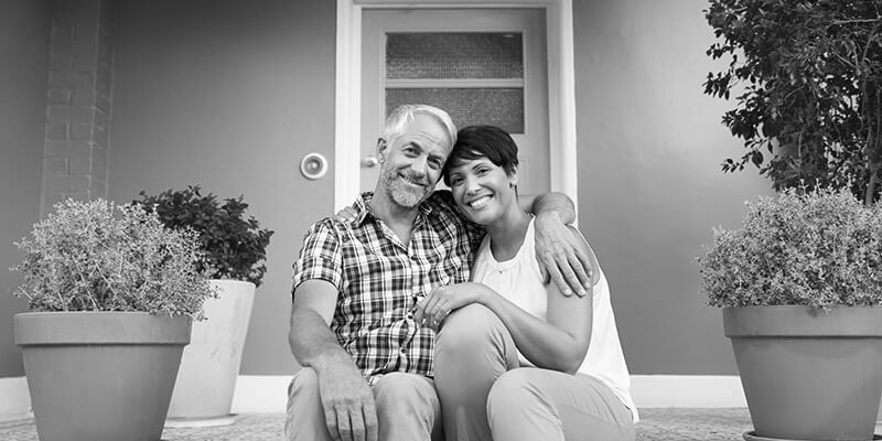 Happy couple sat on a large pretty doorstep