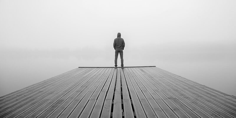 Figure stood at the end of wooden pier