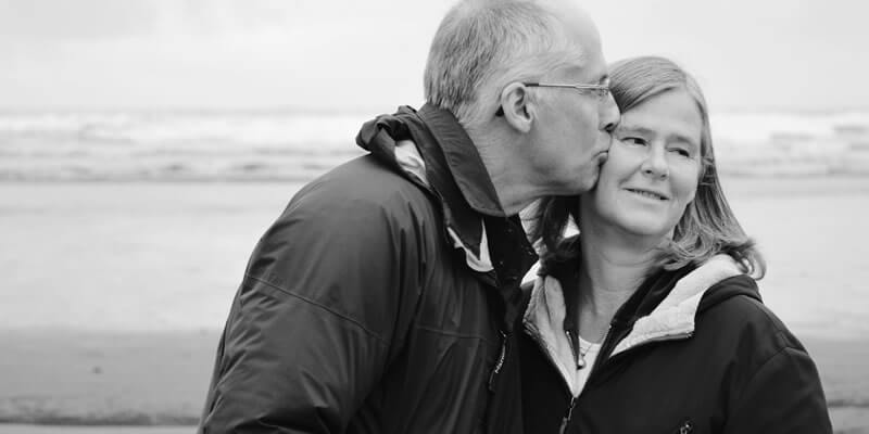 Retired couple kissing on a beach