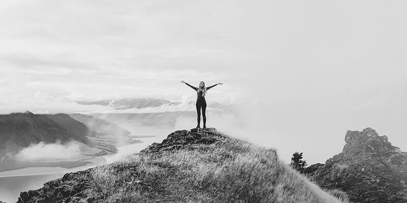 Woman celebrating reaching the top of a mountain