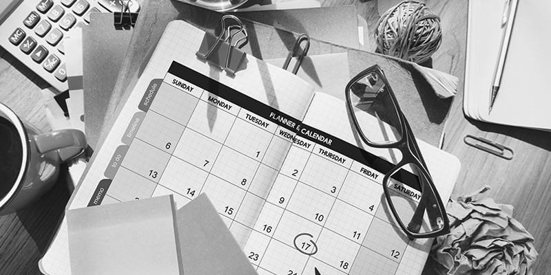 Planner on desk surrounded by stationery 