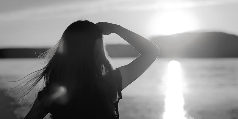 Silhouette of girl looking out to sea