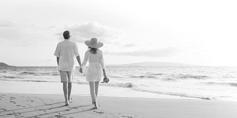 Couple walking barefoot through the sand